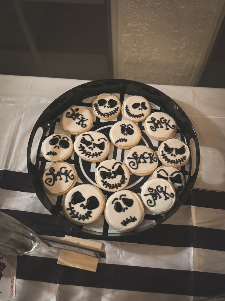 Jack Skellington sugar cookies: round sugar cookies with white icing and Jack Skellington's face piped on top with black icing. A few of the cookies read "Jack" in a fun Halloween font.