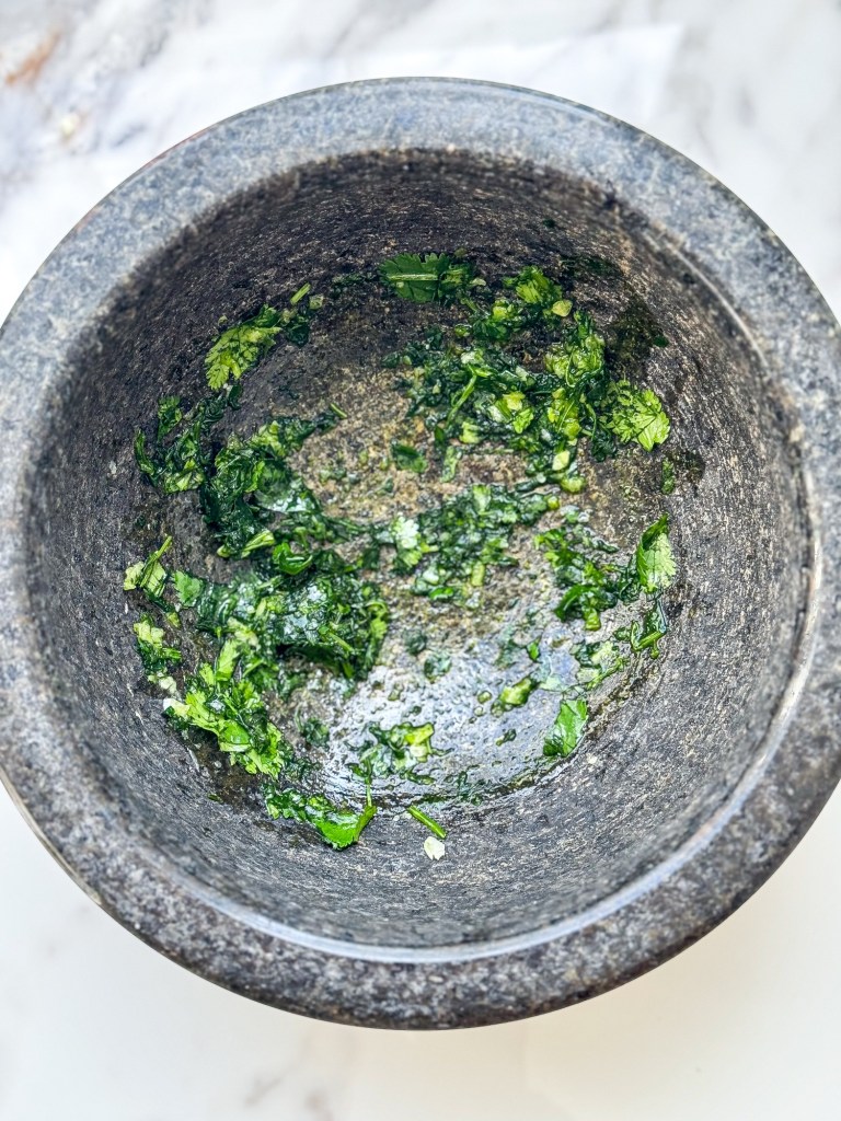 garlic and cilantro in a mortar